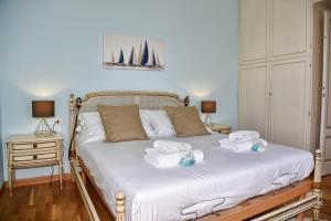 ein Schlafzimmer mit einem Bett mit Handtüchern darauf in der Unterkunft Villa Perledina by Wonderful Italy in Perledo