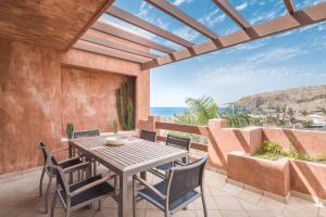 stół i krzesła na tarasie z widokiem na ocean w obiekcie Bahia - Adjona 2,3 PENTHOUSE SEA VIEW & JACUZZI 2B w mieście Palm-Mar