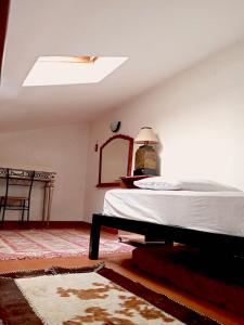 een slaapkamer met een bed en een spiegel bij Casa Claroni 4 pax + 1 letto supplementare in Giuliano di Roma