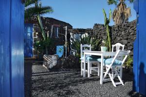 una mesa blanca y dos sillas frente a una casa en Charming Finca with beautiful private gardens, en Uga