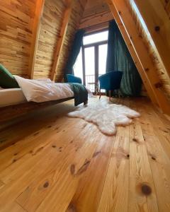 um quarto com uma cama e piso em madeira em EMİS DAĞEVİ em Fındıklı