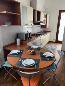 una cocina con una mesa de madera con platos y sillas en Casa dei Tempesta, en Noale