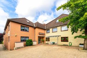 a large brick house with a driveway in front of it at Hotel am Stern Uelzen in Uelzen