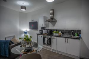 a kitchen with a couch and a table in a room at BV Homely 1 Bedroom Apartment At Shallow HIll Leeds in Huddersfield