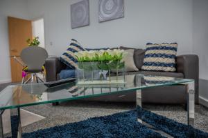 a living room with a couch and a glass table at BV Homely 1 Bedroom Apartment At Shallow HIll Leeds in Huddersfield