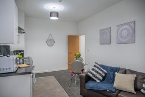 - un salon avec un canapé et une table dans l'établissement BV Homely 1 Bedroom Apartment At Shallow HIll Leeds, à Huddersfield