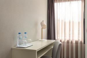 a desk with two bottles of water and a lamp at Empire Marquês Hotel in Lisbon