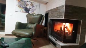 a living room with a chair and a fireplace at Mavrovo Centar Ski Staza in Mavrovo