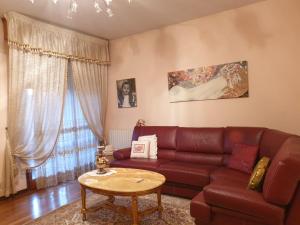 ein Wohnzimmer mit einem roten Sofa und einem Tisch in der Unterkunft Appartamento duplex in Carpi
