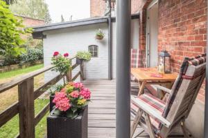 a wooden deck with a table and chairs and flowers at City Apartment Lüneburg in Lüneburg