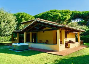 a small house with a wooden deck in a yard at Ville Di Villa Biserno in San Vincenzo