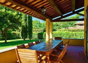 Une table et des chaises en bois sont disponibles sur la terrasse. dans l'établissement Ville Di Villa Biserno, à San Vincenzo