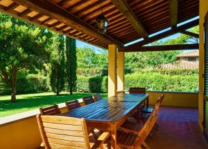 una mesa de madera y sillas en un patio en Ville Di Villa Biserno, en San Vincenzo