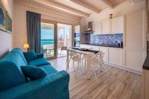 a living room with a blue couch and a table at Luci Apartment Sea Beach in Avola