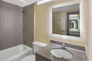 a bathroom with a sink and a toilet and a mirror at Howard Johnson by Wyndham Oklahoma City OKC Airport, Fairgrounds, I40 in Oklahoma City