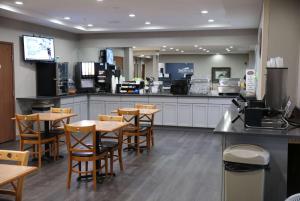 a restaurant with wooden tables and chairs and a counter at Baymont by Wyndham Rockford in Rockford