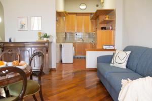 sala de estar con sofá azul y cocina en Casa Rossana - WelcHome, en Cannobio