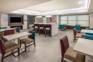 a dining room with tables and chairs and a tv at La Quinta by Wyndham Jonesboro in Jonesboro