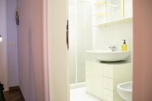 a white bathroom with a sink and a mirror at Casa Rossana - WelcHome in Cannobio +12 photos