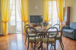 sala de estar con mesa, sillas y sofá en Casa Rossana - WelcHome, en Cannobio