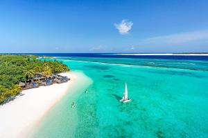 an aerial view of a beach with a boat in the water at Sheraton Maldives Full Moon Resort & Spa in North Male Atoll