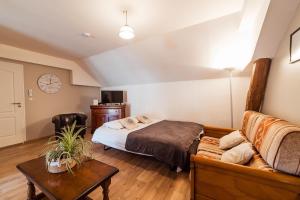 ein Schlafzimmer mit einem Bett und einem Sofa in der Unterkunft Le Millésime - Arbane in Buchères