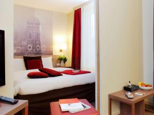 a hotel room with a bed and a mirror at Aparthotel Adagio Muenchen City in Munich