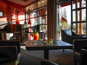 une table avec deux vases dans un restaurant dans l'établissement Hotel Parc Beaumont & Spa Pau - MGallery, à Pau