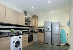 a kitchen with stainless steel appliances and wooden cabinets at Smithdown service accommodation in Liverpool