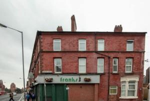 a red brick building with a pharmacy sign on it at Smithdown service accommodation in Liverpool
