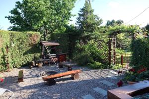 ogród z drewnianą ławką i ogrodzeniem w obiekcie Domek Letniskowy w mieście Mrągowo