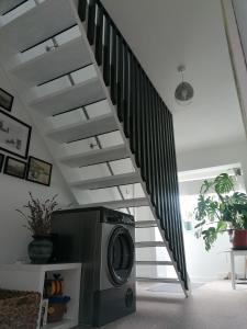a staircase in a living room with a washing machine at Port Side Brixham - Ideal seaside getaway - parking - wood-burner - dog friendly in Brixham