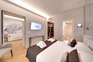 サンレモにあるベストウェスタン ホテル ナツィオナーレのベッドルーム(大きな白いベッド1台、テレビ付)