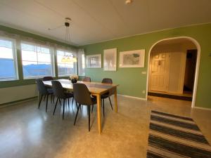 une salle à manger avec des murs verts et une table et des chaises en bois dans l'établissement Lovely house in Abisko, à Abisko