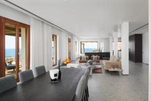 sala de estar con mesa y sala de estar con sofá en Luxury Villa over the Cliffs & Wild Beach by FeelHome en Bet Yannay