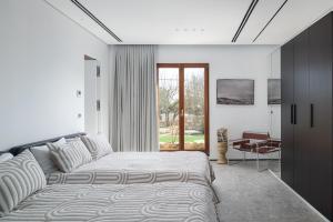 Dormitorio blanco con cama y mesa en Luxury Villa over the Cliffs & Wild Beach by FeelHome en Bet Yannay
