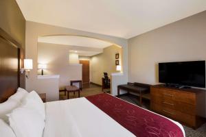 a hotel room with a bed and a flat screen tv at Comfort Suites Near University in North Brunswick