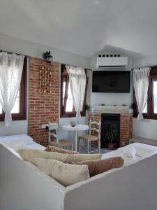 a living room with white furniture and a fireplace at VILLA KALDERA in Skiathos Town