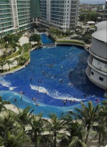 uma grande piscina num resort com pessoas em Staycation at Azure by Melissa em Manila