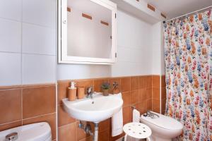 uma casa de banho com um lavatório, um WC e um espelho. em Home2Book Poris Ocean View em Poris de Abona