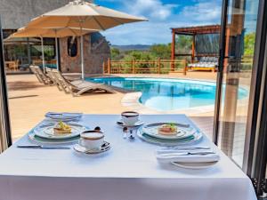 a table with plates of food on it next to a pool at Mont Eco Game Reserve in Montagu