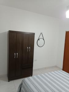 een slaapkamer met een bruine kast en een bed bij Residencial Alto Xurupita in Porto Seguro