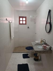 een witte badkamer met een wastafel en een toilet bij Residencial Alto Xurupita in Porto Seguro