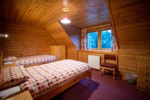 a bedroom with two beds in a wooden cabin at Badaguish forest lodges and camping pods in Aviemore