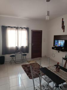 sala de estar con mesa y TV. en Residencial Alto Xurupita, en Porto Seguro