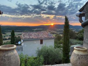 ein Gebäude mit Sonnenuntergang im Hintergrund in der Unterkunft Auberge Prieuré du Vieux Fox in Fox-Amphoux