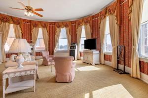 uma sala de estar com um sofá e uma televisão em Windsor Hotel, Ascend Hotel Collection em Americus
