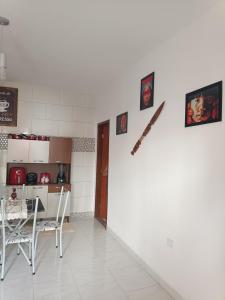 een keuken met een tafel en een klok aan de muur bij Residencial Alto Xurupita in Porto Seguro