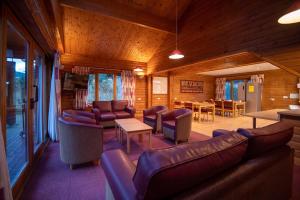 ein Wohnzimmer mit Sofas, Stühlen und einem Tisch in der Unterkunft Badaguish forest lodges and camping pods in Aviemore