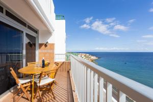 uma varanda com uma mesa e cadeiras e o oceano em Home2Book Poris Ocean View em Poris de Abona